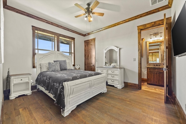 bedroom with ornamental molding, ensuite bathroom, ceiling fan, and dark hardwood / wood-style flooring