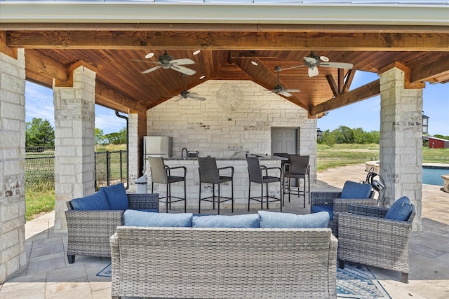 view of patio / terrace with ceiling fan, a wet bar, and an outdoor hangout area