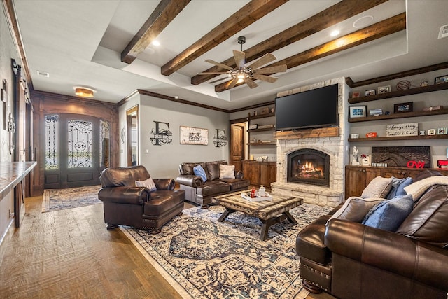 living area featuring a fireplace, a ceiling fan, visible vents, beam ceiling, and wood finished floors