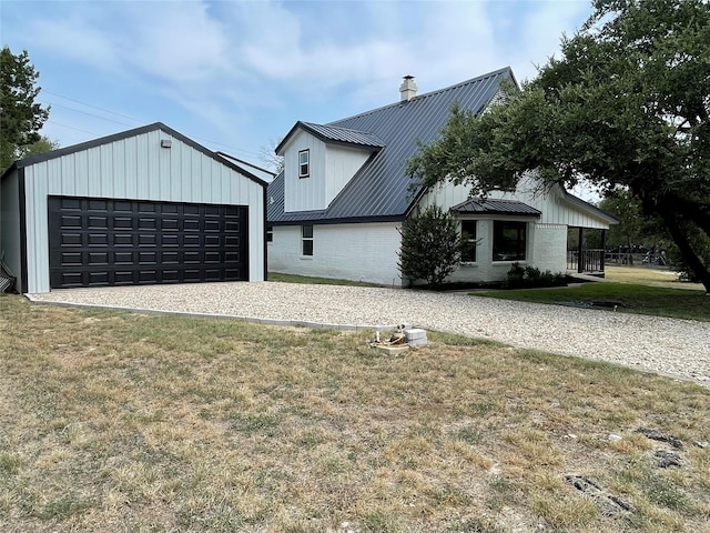 modern inspired farmhouse featuring a garage, metal roof, a chimney, and a front yard