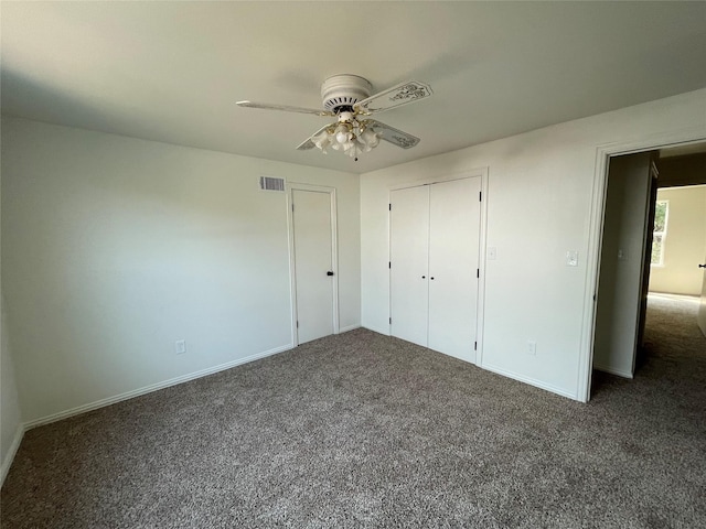 unfurnished bedroom with dark colored carpet, a closet, visible vents, a ceiling fan, and baseboards