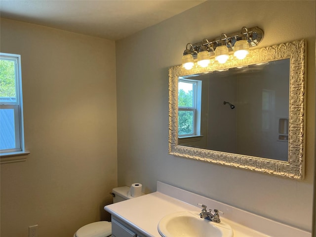 bathroom with plenty of natural light, vanity, and toilet