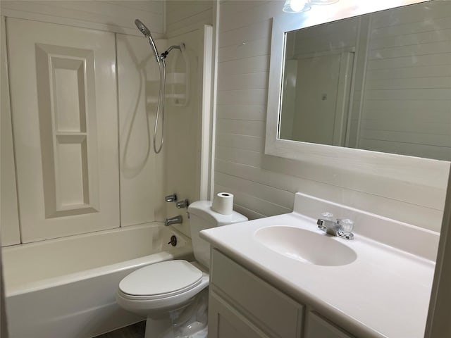 full bath featuring bathtub / shower combination, wood walls, vanity, and toilet