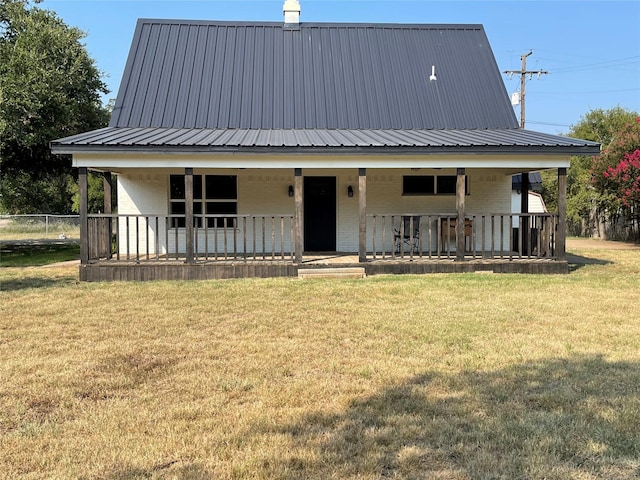 view of front of home with a front yard, metal roof, and brick siding