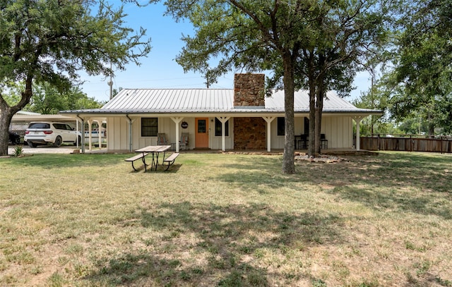 rear view of property with a porch, a carport, and a yard