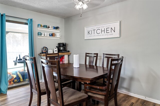 dining room featuring ceiling fan, a textured ceiling, and wood-type flooring