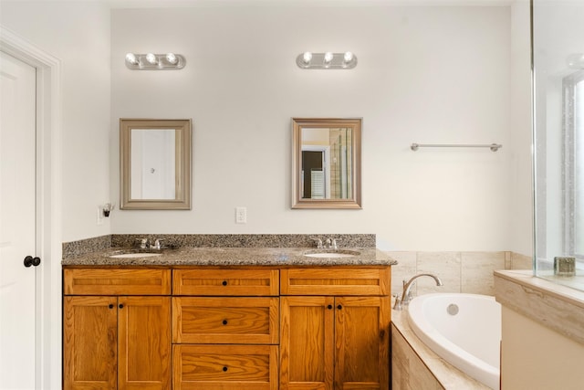 bathroom featuring vanity and tiled tub