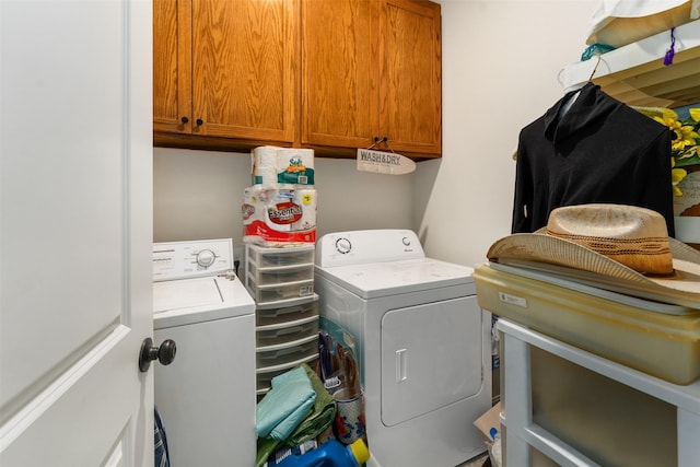 clothes washing area featuring washer and dryer and cabinets