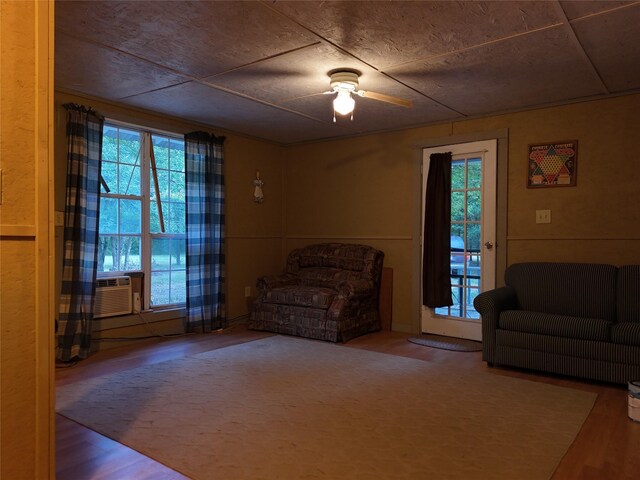 sitting room featuring hardwood / wood-style floors, cooling unit, and ceiling fan