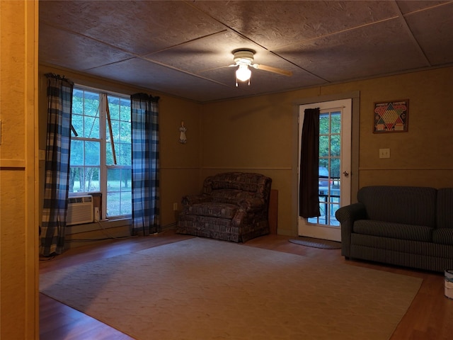 living area featuring cooling unit, ceiling fan, and hardwood / wood-style floors