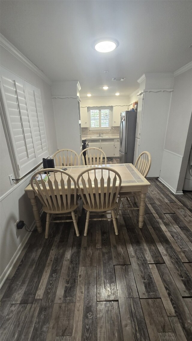 dining room with wood-type flooring and crown molding