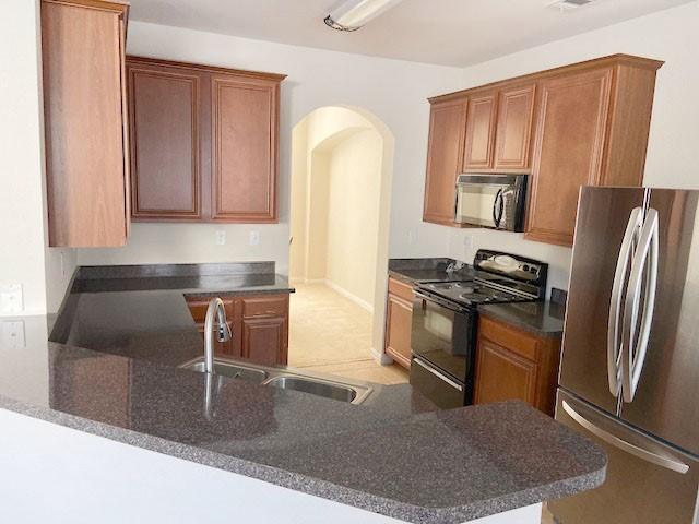 kitchen featuring kitchen peninsula, black appliances, and sink