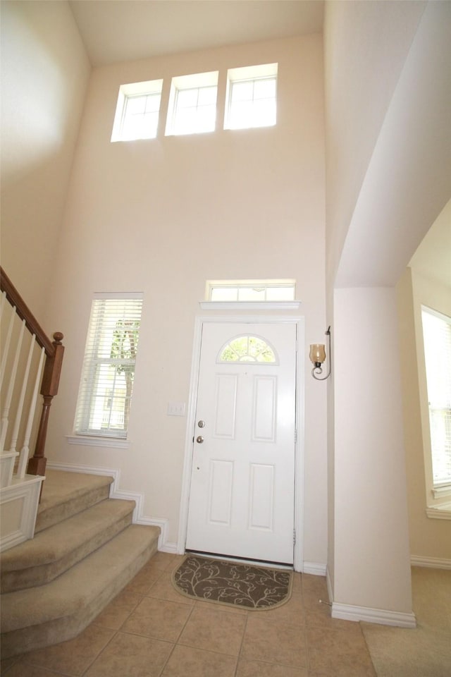 foyer featuring a towering ceiling and light tile patterned flooring