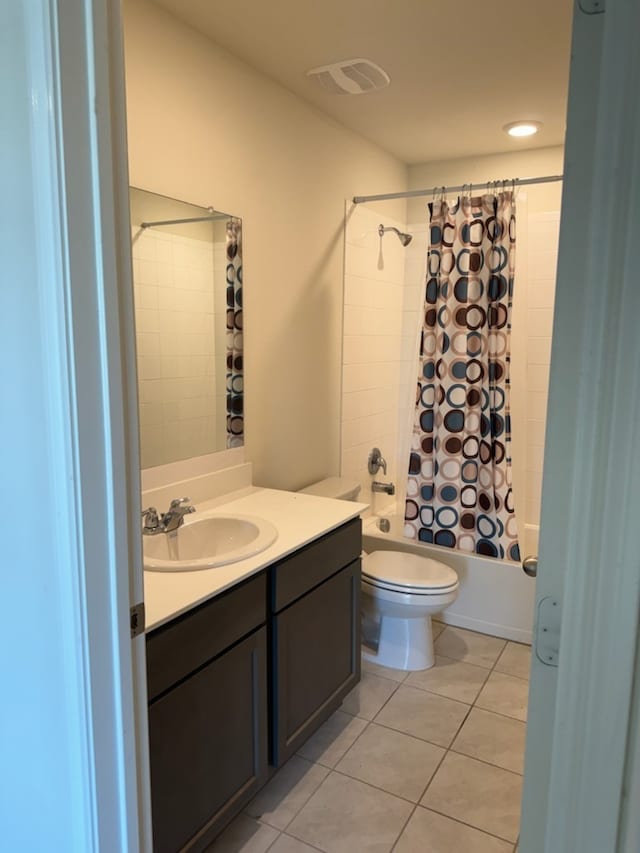 full bath featuring tile patterned flooring, shower / bath combo with shower curtain, vanity, and toilet