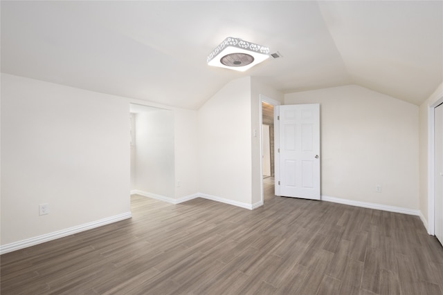 unfurnished bedroom with lofted ceiling, a closet, and dark hardwood / wood-style floors