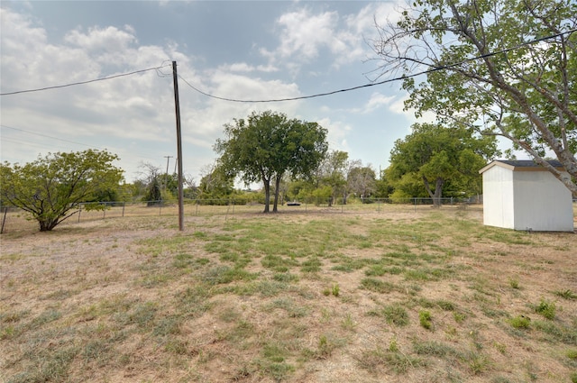 view of yard featuring a rural view and a storage unit