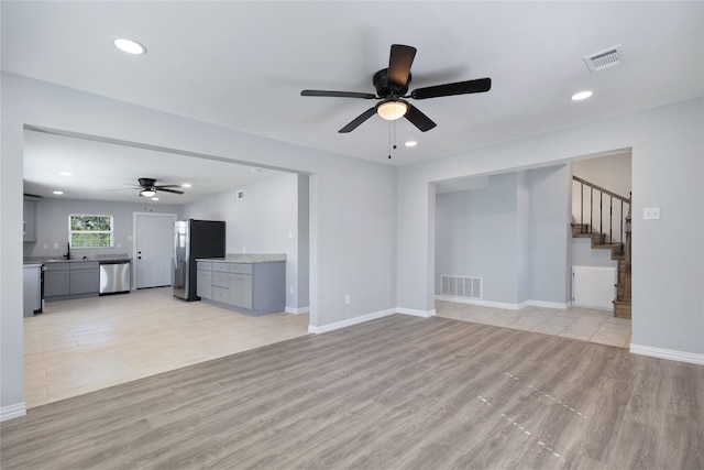 kitchen with gray cabinets, stainless steel refrigerator with ice dispenser, and a wealth of natural light