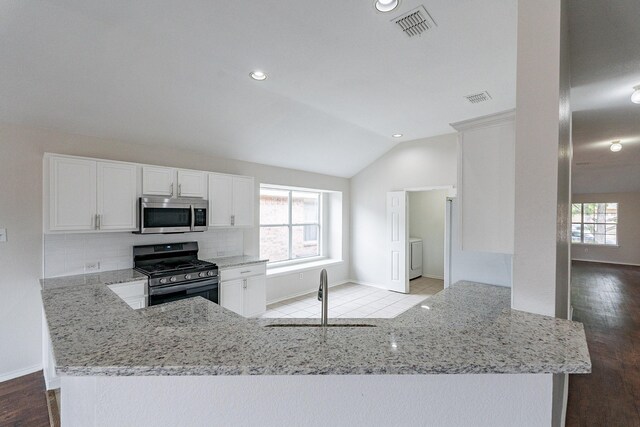 kitchen with stainless steel appliances, white cabinets, sink, light hardwood / wood-style floors, and kitchen peninsula