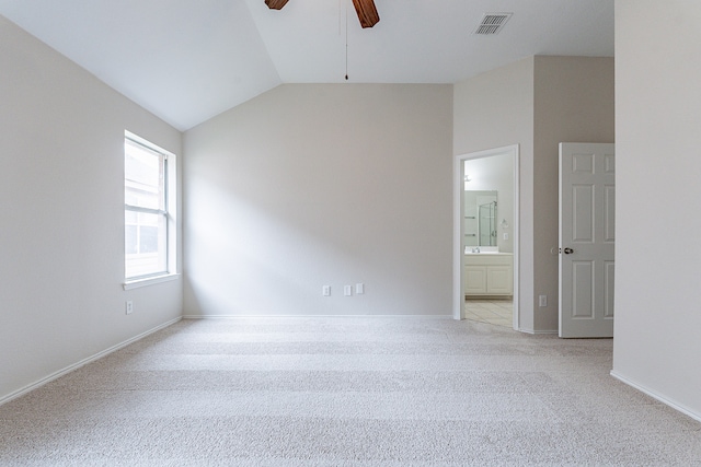 spare room with ceiling fan, lofted ceiling, and light colored carpet