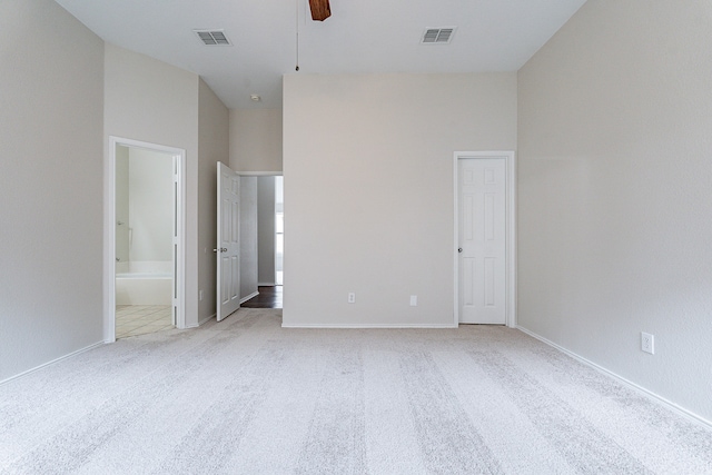 unfurnished bedroom featuring ensuite bathroom, ceiling fan, and carpet flooring