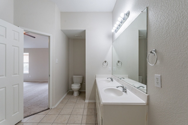 bathroom featuring double sink vanity, ceiling fan, tile patterned flooring, and toilet