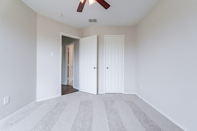 unfurnished bedroom with a closet, ceiling fan, and carpet floors