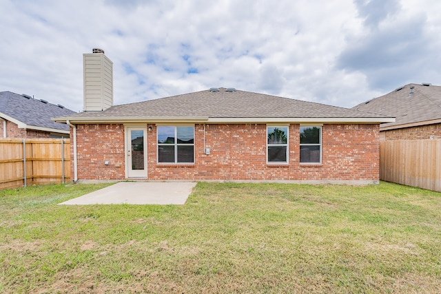 rear view of property featuring a yard and a patio area