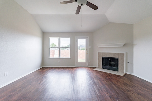 unfurnished living room featuring hardwood / wood-style floors, vaulted ceiling, ceiling fan, and a tile fireplace