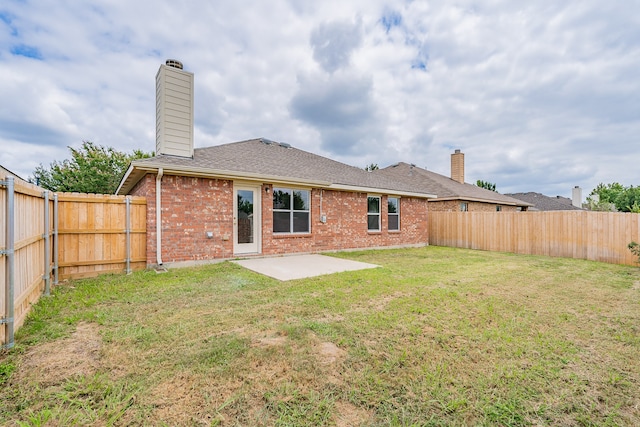 back of property with a patio area and a yard