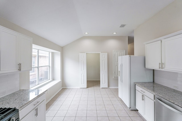 kitchen featuring decorative backsplash, light tile patterned flooring, stainless steel dishwasher, white cabinets, and vaulted ceiling