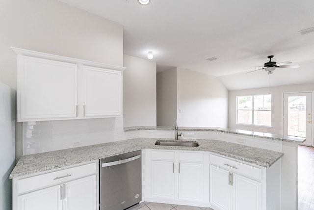 kitchen with stainless steel dishwasher, light stone counters, ceiling fan, sink, and kitchen peninsula