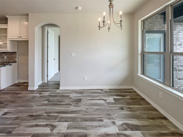 unfurnished dining area featuring tile patterned floors and a chandelier