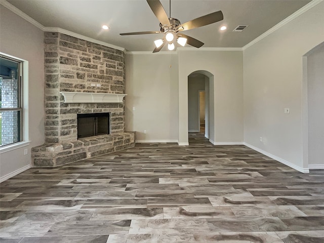 unfurnished living room featuring ceiling fan, a fireplace, and ornamental molding