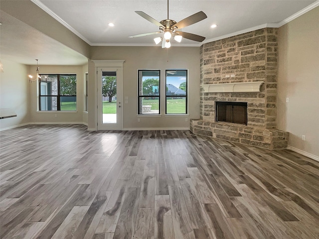 unfurnished living room with a fireplace, hardwood / wood-style floors, ceiling fan, and crown molding