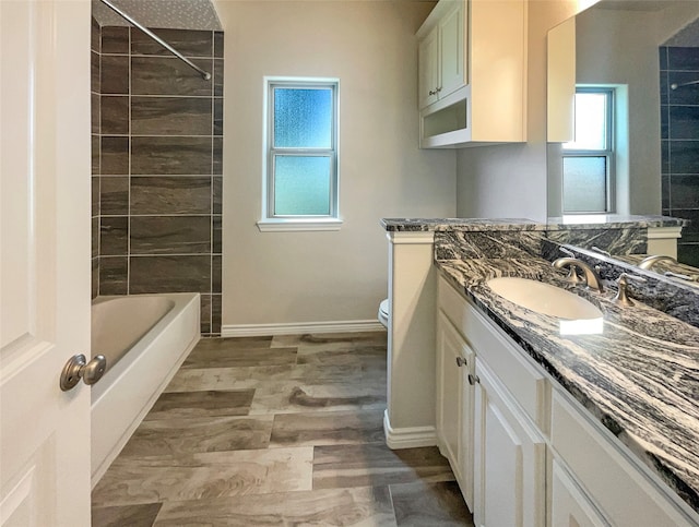 full bathroom with tile patterned floors, tiled shower / bath combo, vanity, and toilet