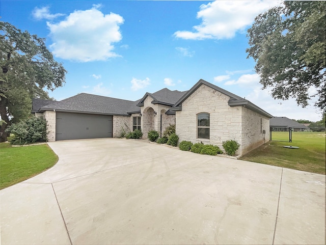 french country style house with a front lawn and a garage