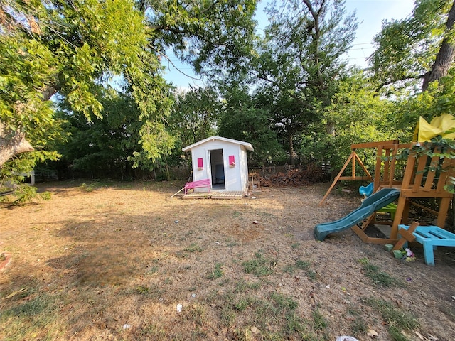 view of yard featuring a playground and a storage unit