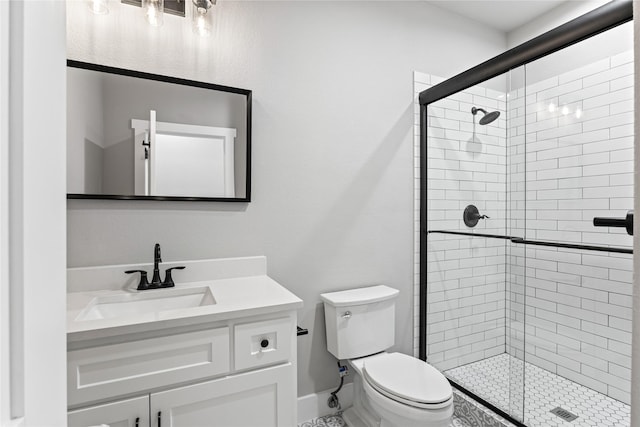 bathroom featuring vanity, a shower with shower door, and toilet