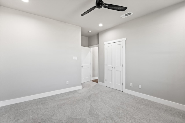 unfurnished bedroom with light carpet, a closet, and ceiling fan