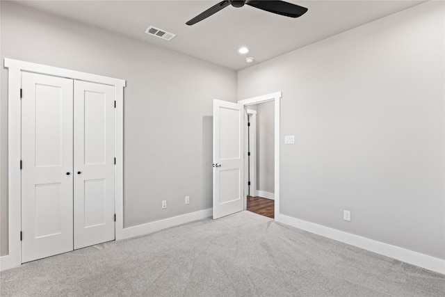 unfurnished bedroom featuring light colored carpet, ceiling fan, and a closet