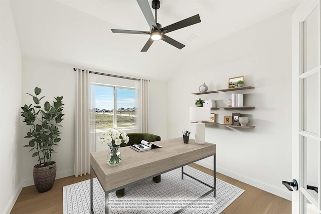 home office featuring ceiling fan, vaulted ceiling, and hardwood / wood-style flooring