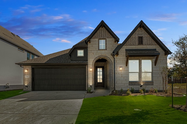 view of front of house featuring a garage and a lawn