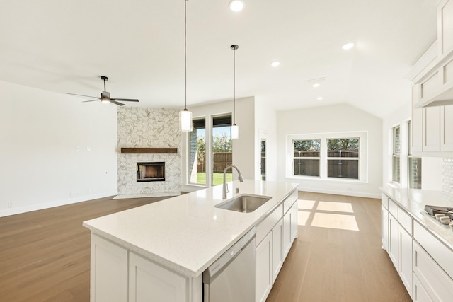 kitchen with white cabinetry, sink, appliances with stainless steel finishes, and an island with sink