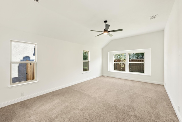 empty room with ceiling fan, light colored carpet, and lofted ceiling