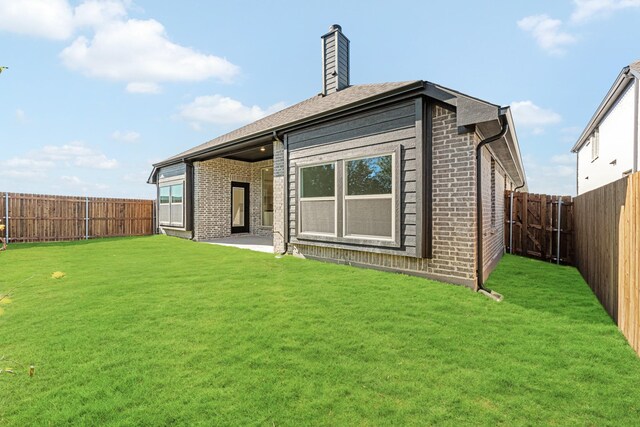 back of house featuring a yard and a patio