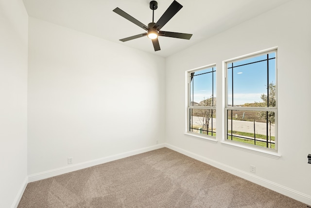 carpeted spare room featuring ceiling fan