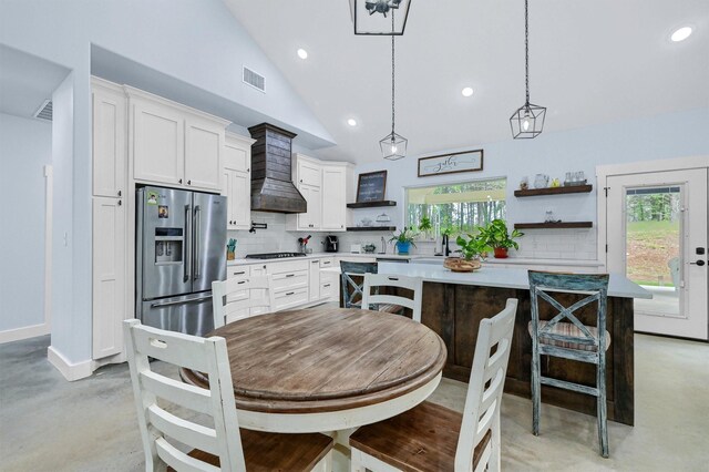 dining room with high vaulted ceiling and a wealth of natural light