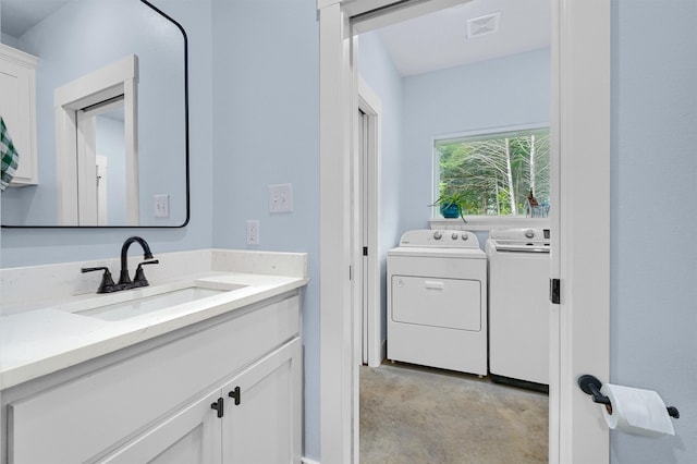 bathroom with washing machine and clothes dryer and vanity