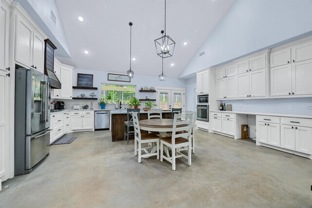 kitchen featuring pendant lighting, appliances with stainless steel finishes, a breakfast bar area, high vaulted ceiling, and a kitchen island