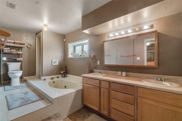 bathroom featuring double sink vanity, toilet, tile patterned floors, and tiled bath